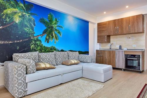 uma sala de estar com um sofá branco e um mural de palmeiras em Apartament Bora Bora Boutik Cytadell em Eforie Nord