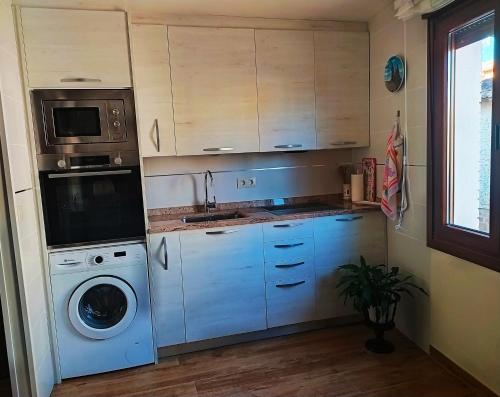 a kitchen with a washing machine and a washer at El Rincón de Pilar in Casalarreina