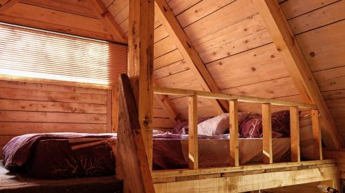 an attic room with a bed in a wooden cabin at Bungalows Old Town in Visoko