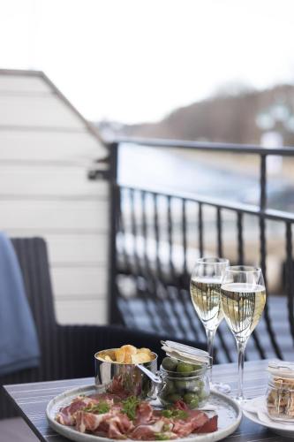 a table with a plate of food and two glasses of wine at Åtellet Hotell in Norrtälje