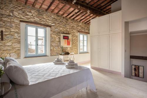 1 dormitorio con 1 cama en una pared de piedra en La Casetta di Nise, charming private spa, en Castelnuovo dellʼAbate