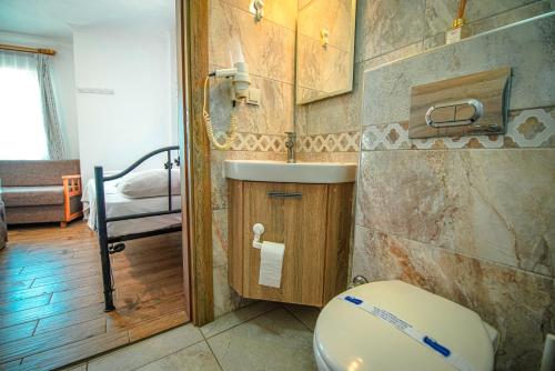 ein Badezimmer mit Toilette und Waschbecken in der Unterkunft Bozcaada Vitis Hotel in Bozcaada