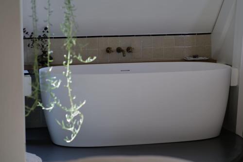 a white bath tub sitting in a bathroom at Boutique B&B in Edam in Edam