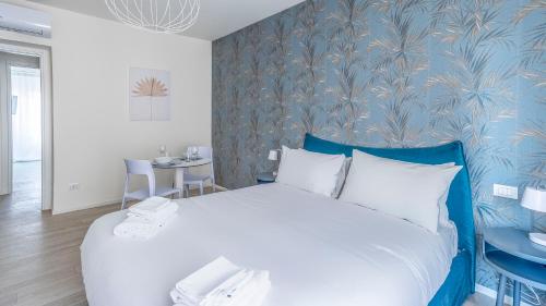 um quarto com uma cama grande e uma parede azul em Italianway - The B Village New em Milão