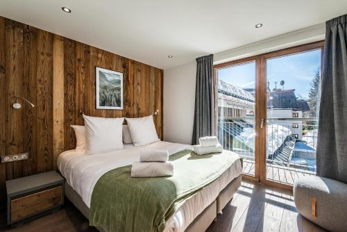 une chambre avec un grand lit et une grande fenêtre dans l'établissement Chalet Badi Argentière Chamonix - by EMERALD STAY, à Chamonix-Mont-Blanc