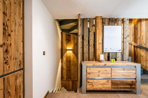 Cette chambre dispose de murs en bois, d'une commode et d'un couloir. dans l'établissement Chalet Badi Argentière Chamonix - by EMERALD STAY, à Chamonix-Mont-Blanc