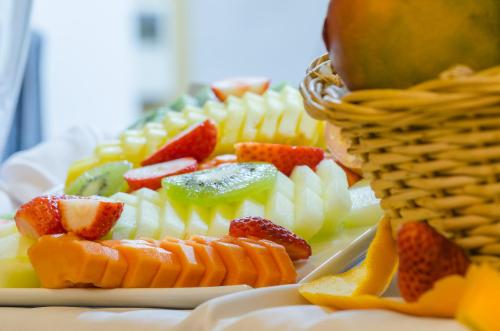 a plate of fruit on a table with a basket at Nicola Rossio Hotel in Lisbon