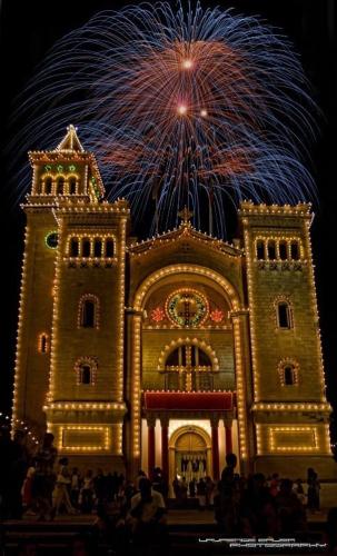 a building with fireworks in the background with people standing in front at Sea view apartment in Birżebbuġa