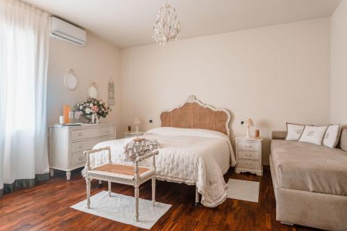 una camera con letto, sedia e cassettiera di Villa Diletta b&b a Forte dei Marmi