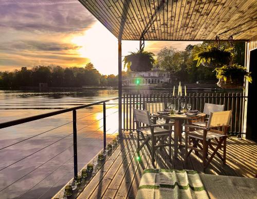 a table and chairs on a deck with a view of the water at Brindos, Lac & Château - Relais & Châteaux - Anglet Biarritz in Anglet