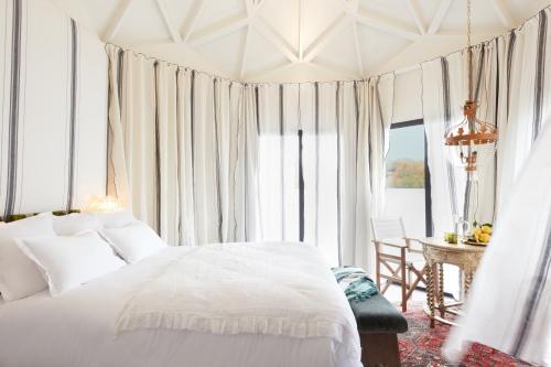 a bedroom with a white bed and a table and window at Brindos, Lac & Château - Relais & Châteaux - Anglet Biarritz in Anglet