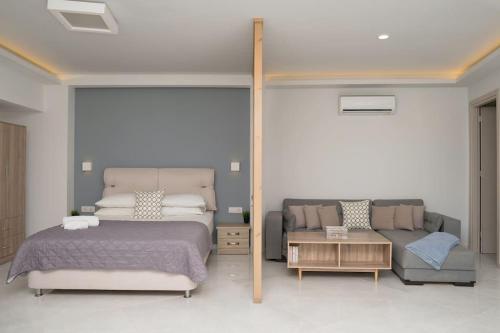 a bedroom with a bed and a couch at Beach Luxury Suite in Tsilivi