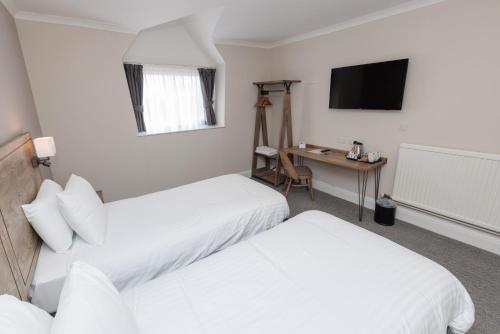 a hotel room with two beds and a desk at Olde House, Chesterfield by Marston's Inns in Chesterfield