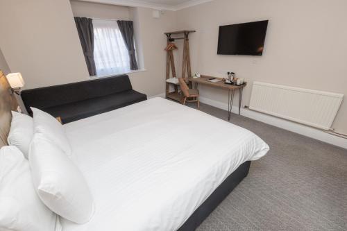 a bedroom with a white bed and a television at Olde House, Chesterfield by Marston's Inns in Chesterfield