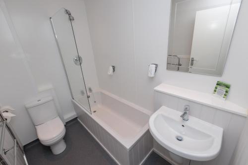 a white bathroom with a toilet and a sink at Olde House, Chesterfield by Marston's Inns in Chesterfield