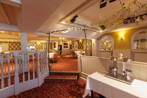 a restaurant with tables and chairs in a room at Olde House, Chesterfield by Marston's Inns in Chesterfield