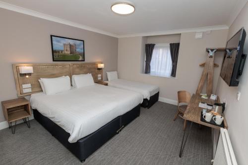 a hotel room with two beds and a television at Olde House, Chesterfield by Marston's Inns in Chesterfield