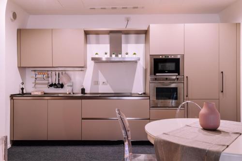 uma cozinha com armários brancos e uma mesa em Appartamento elegante alle Due Torri by Wonderful Italy em Bolonha