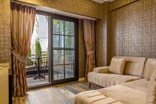 a living room with a couch and a sliding glass door at THE LEA HOTELS & SUITE in Didim
