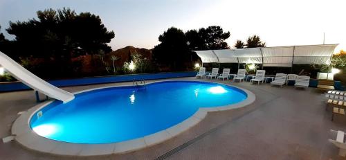 a large swimming pool with chairs and a building at Terra Nostra in Cattolica Eraclea