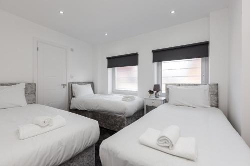 a white room with two beds and two windows at RST Luxury Aparthotel in Liverpool