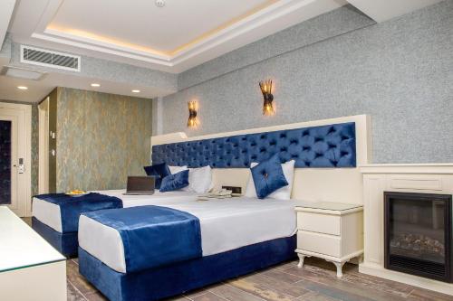 a blue bedroom with a large bed and a fireplace at THE LEA HOTELS & SUITE in Didim