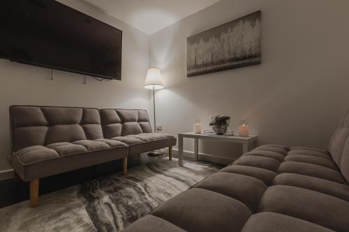 a living room with two couches and a flat screen tv at RST Luxury Aparthotel in Liverpool