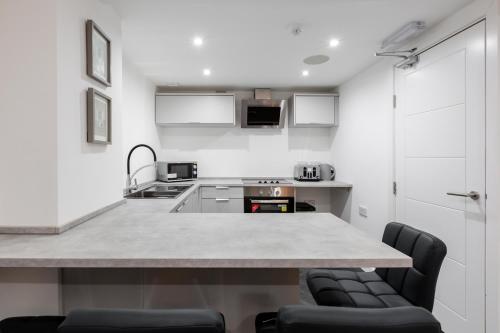 a kitchen with a counter and two chairs at RST Luxury Aparthotel in Liverpool