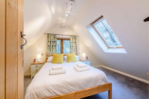 a bedroom with a large bed with yellow pillows at The Nest at Robins Roost in Little Rissington