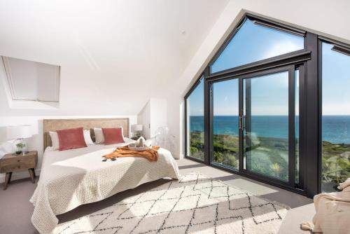 a bedroom with a bed and a large window at Ocean View, The Sands in Praa Sands
