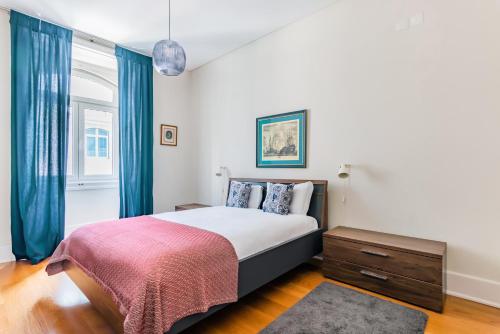 リスボンにあるDowntown 75 Prestige in Baixaのベッドルーム1室(青いカーテン付きの大型ベッド1台付)