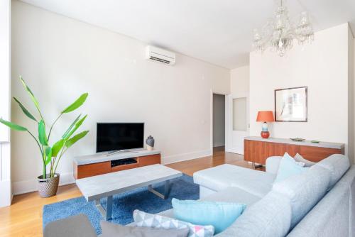 a living room with a white couch and a tv at Downtown 75 Prestige in Baixa in Lisbon