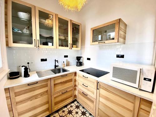 La cuisine est équipée de placards en bois, d'un évier et d'un four micro-ondes. dans l'établissement Les Mouettes à Deauville, à Deauville