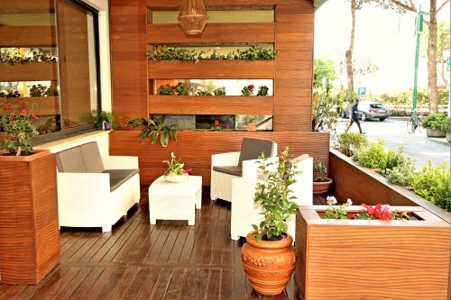 a patio with white chairs and potted plants at Residence & Suites in Bellaria-Igea Marina