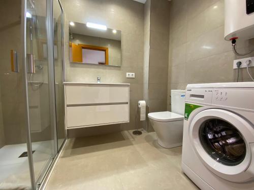 a bathroom with a washing machine and a toilet at Zodiac 1. in Alcudia