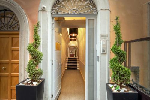 un corridoio con due piante in vaso in un edificio di Condotti Palace a Roma