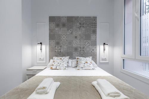 Habitación blanca con cama grande con almohadas en Room close to City Centre, en Valencia