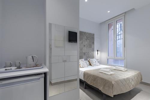 um quarto branco com uma cama e um lavatório em Room close to City Centre em Valência