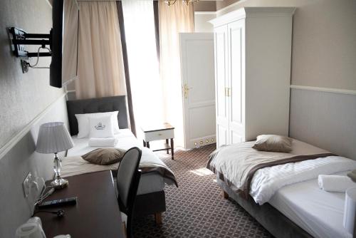 Radziejów的住宿－Arkadia，酒店客房设有两张床、一张书桌和一个窗户。
