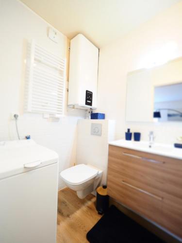 uma casa de banho branca com um WC e um lavatório em ROCHAMBEAU - Moderne - Face aux Thermes - Parking - em Vichy