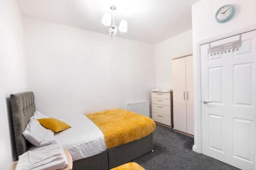 a bedroom with a bed and a clock on the wall at Modern apartment close to city centre with parking in Leeds