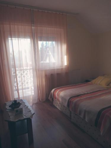 ハイドゥソボスローにあるOlga Apartmanházのベッドルーム(ベッド1台、窓付)