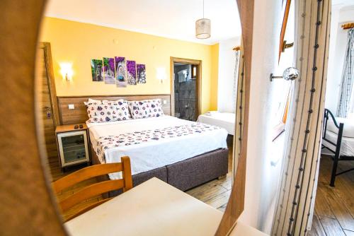 ein Schlafzimmer mit einem Bett, einem Tisch und einem Stuhl in der Unterkunft Bozcaada Vitis Hotel in Bozcaada