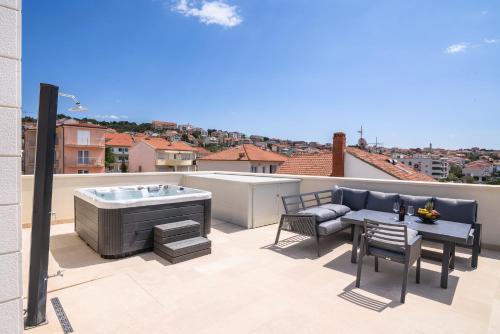 a patio with a hot tub and a table and chairs at Ero on the beach in Trogir