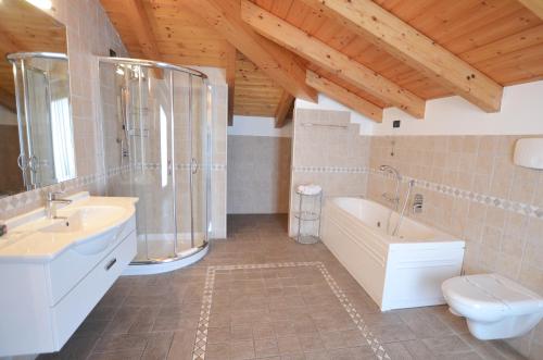 a bathroom with two sinks and a tub and a toilet at Residence Alle Palme in Riva del Garda