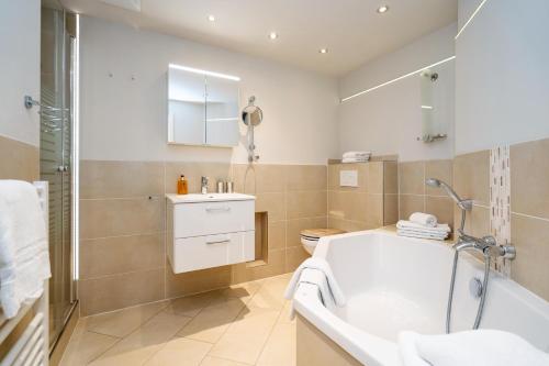 ein Badezimmer mit Badewanne, Waschbecken und Toilette in der Unterkunft Süderliebe in Westerland