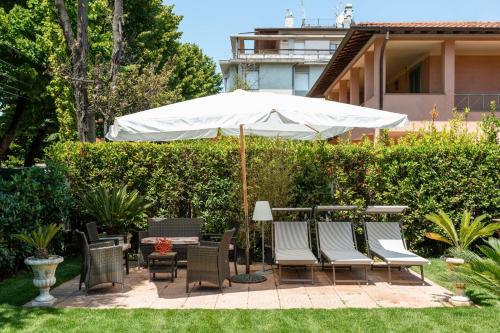 a patio with a table and chairs and an umbrella at Villa Diletta b&b in Forte dei Marmi
