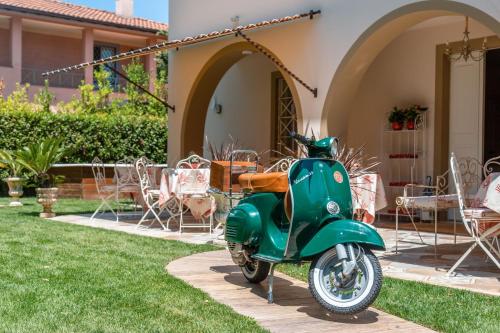a green scooter parked in front of a house at Villa Diletta b&b in Forte dei Marmi
