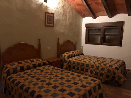 - une chambre avec 2 lits et une fenêtre dans l'établissement Casas Rurales Hoya Calvete, à Yeste