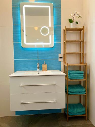 un bagno con lavandino e specchio di Ocean Sunset Apartment a Paphos